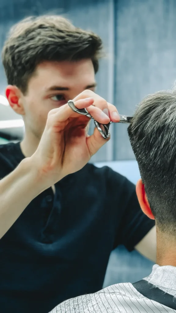Scissors and comb shaping short salt-and-pepper hair