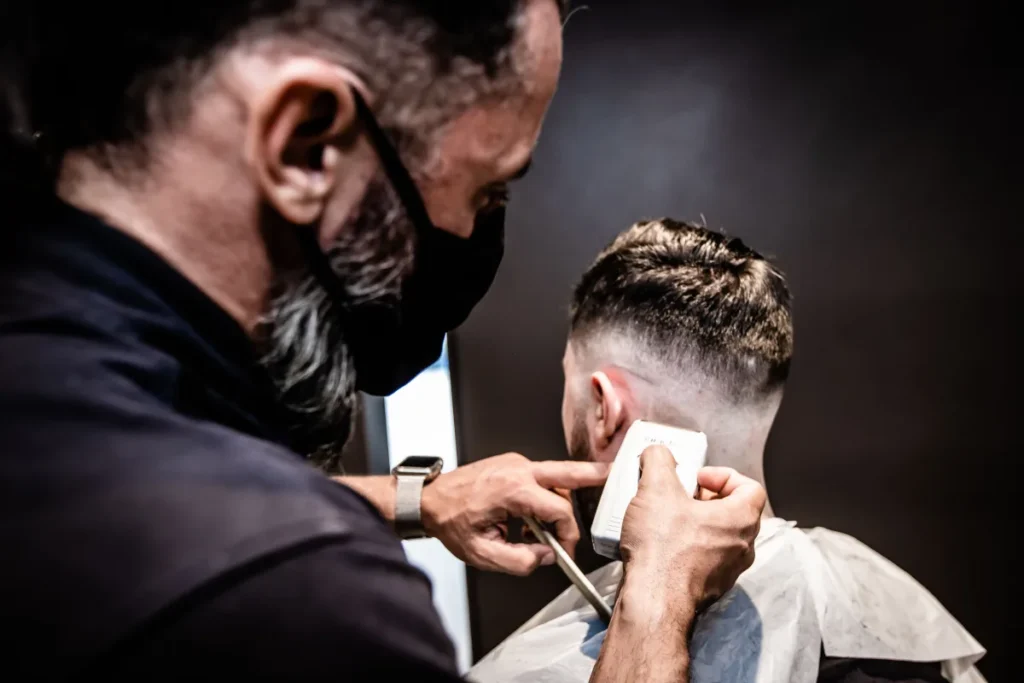 Barber refining a close fade with clippers
