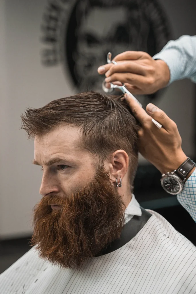 Profile of a bearded client receiving a scissor haircut